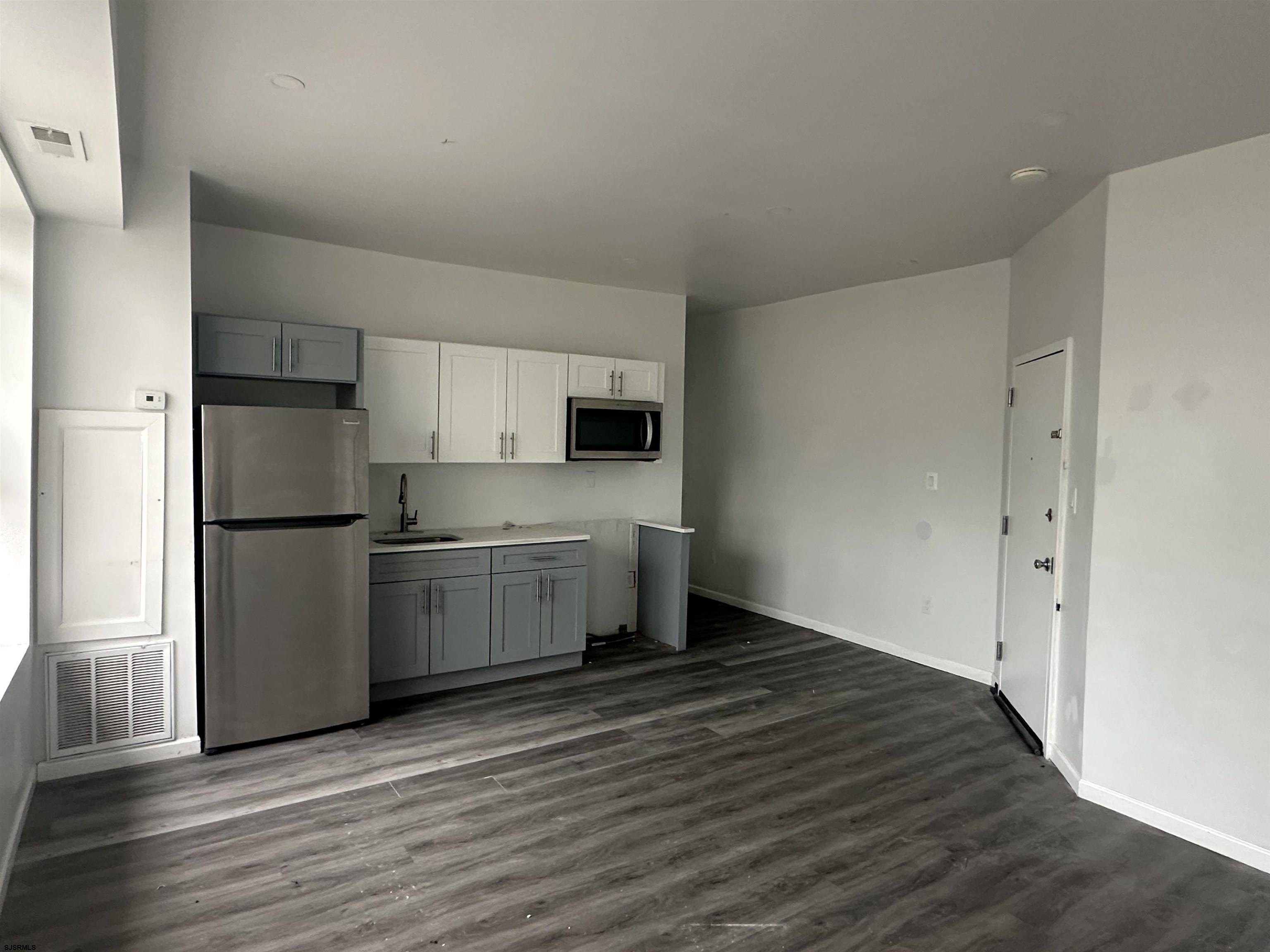 225 Atlantic Avenue, Unit B7 Atlantic City, NJ 08401 - Photo 24 of 28 a kitchen with a refrigerator sink and cabinets