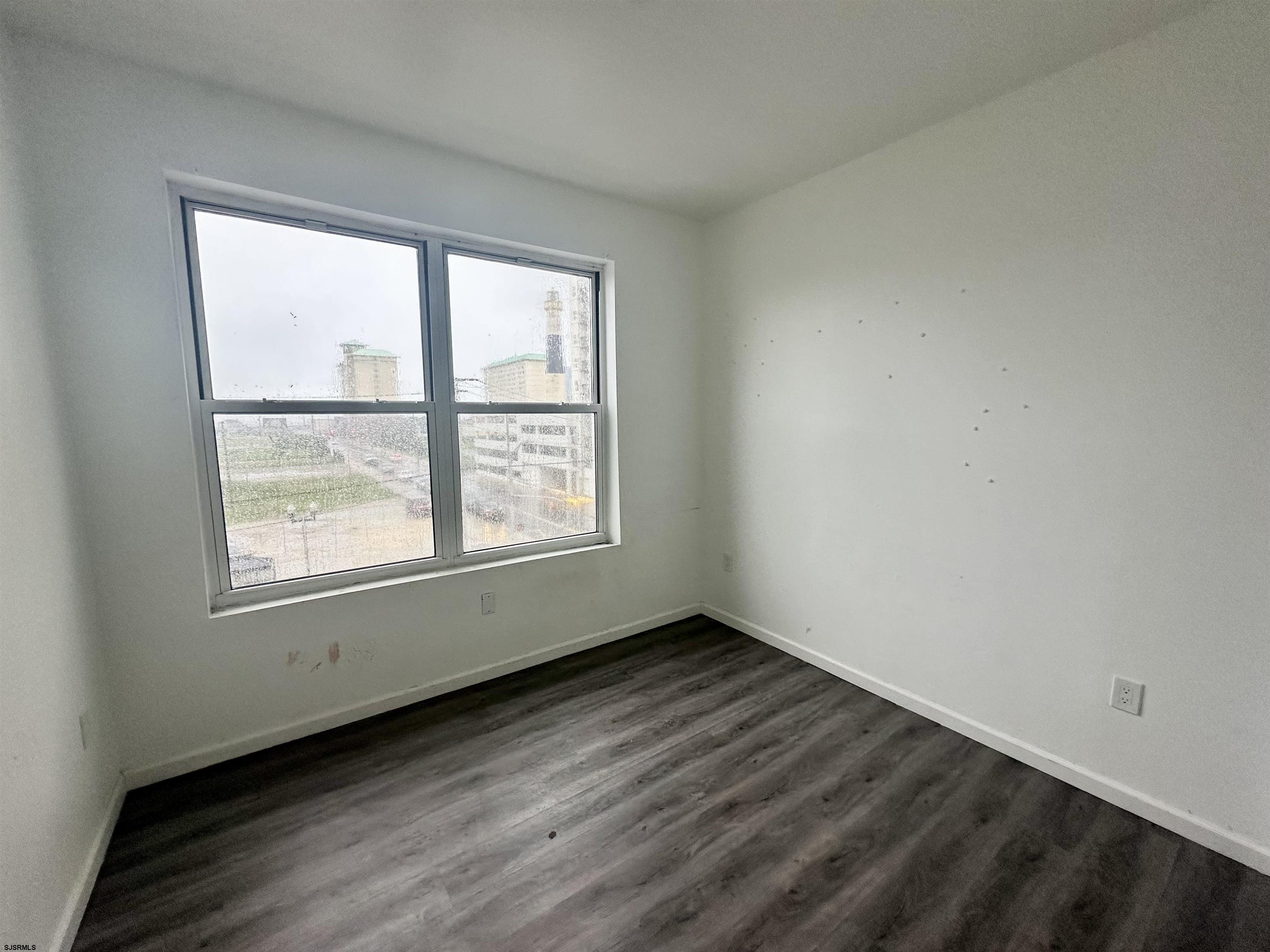 225 Atlantic Avenue, Unit B7 Atlantic City, NJ 08401 - Photo 28 of 28 an empty room with wooden floor and windows