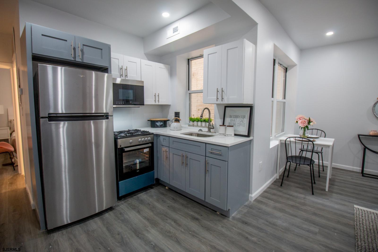 225 Atlantic Avenue, Unit B7 Atlantic City, NJ 08401 - Photo 5 of 28 a kitchen with a refrigerator stove and wooden floor