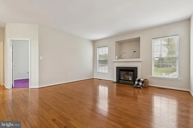 a view of a livingroom with wooden floor a fireplace and window
