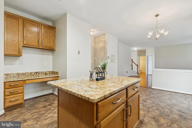 a kitchen with granite countertop a stove top oven a sink dishwasher a refrigerator and cabinets with wooden floor