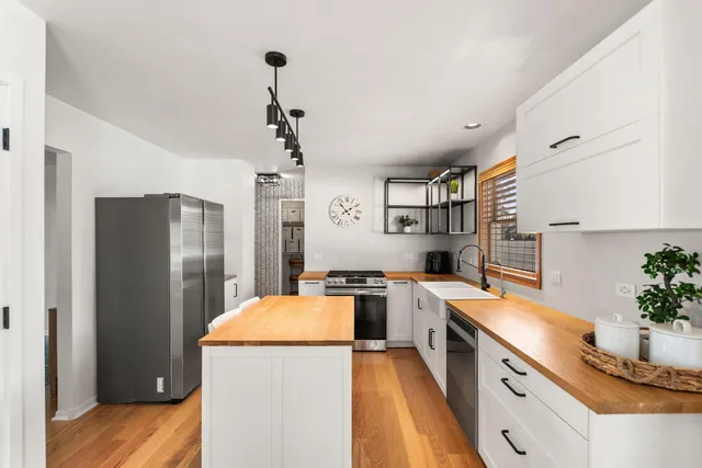 a kitchen with stainless steel appliances a refrigerator sink and wooden floor