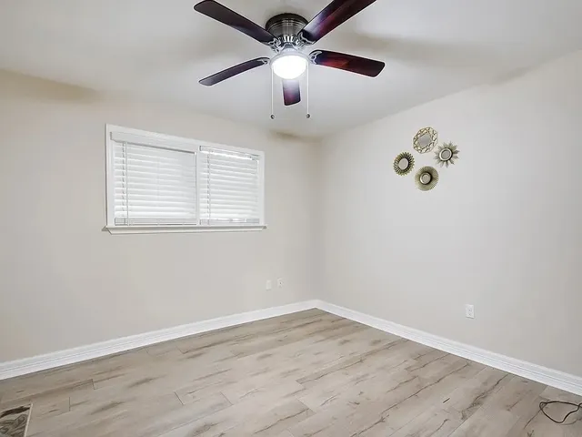 a front view of a house with a garden and trees