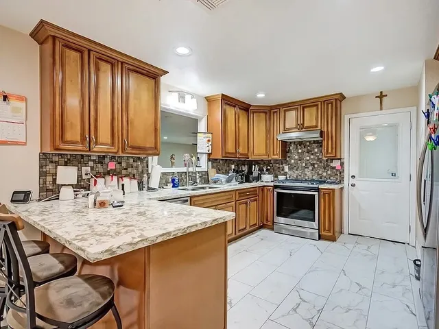 a kitchen with stainless steel appliances granite countertop a stove a sink and a microwave