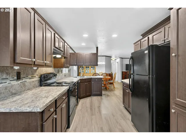 a kitchen with stainless steel appliances granite countertop a refrigerator a stove a sink and a microwave