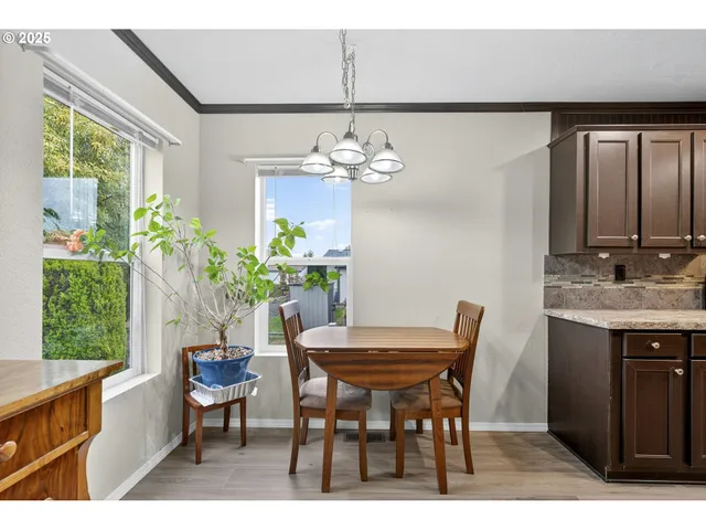 a dining room with furniture a potted plant and a chandelier