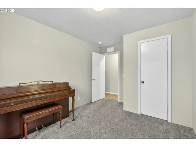 a hallway with a piano and wooden floor