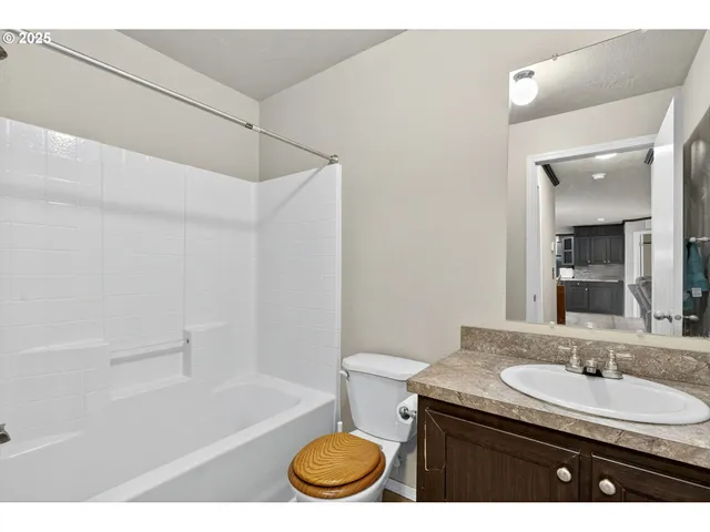 a bathroom with a granite countertop sink toilet and shower