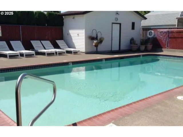 a view of a swimming pool with lawn chairs