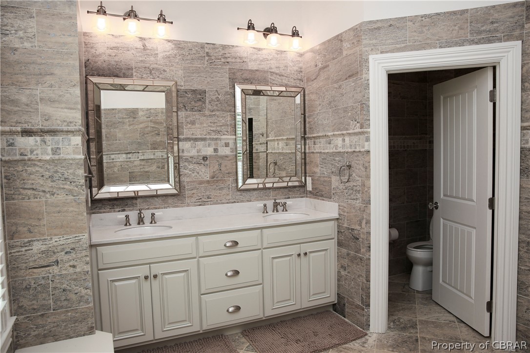 1000 Queenstown Road Lancaster, VA 22503 - Photo 42 of 49 a bathroom with a double vanity sink a mirror and a bathtub
