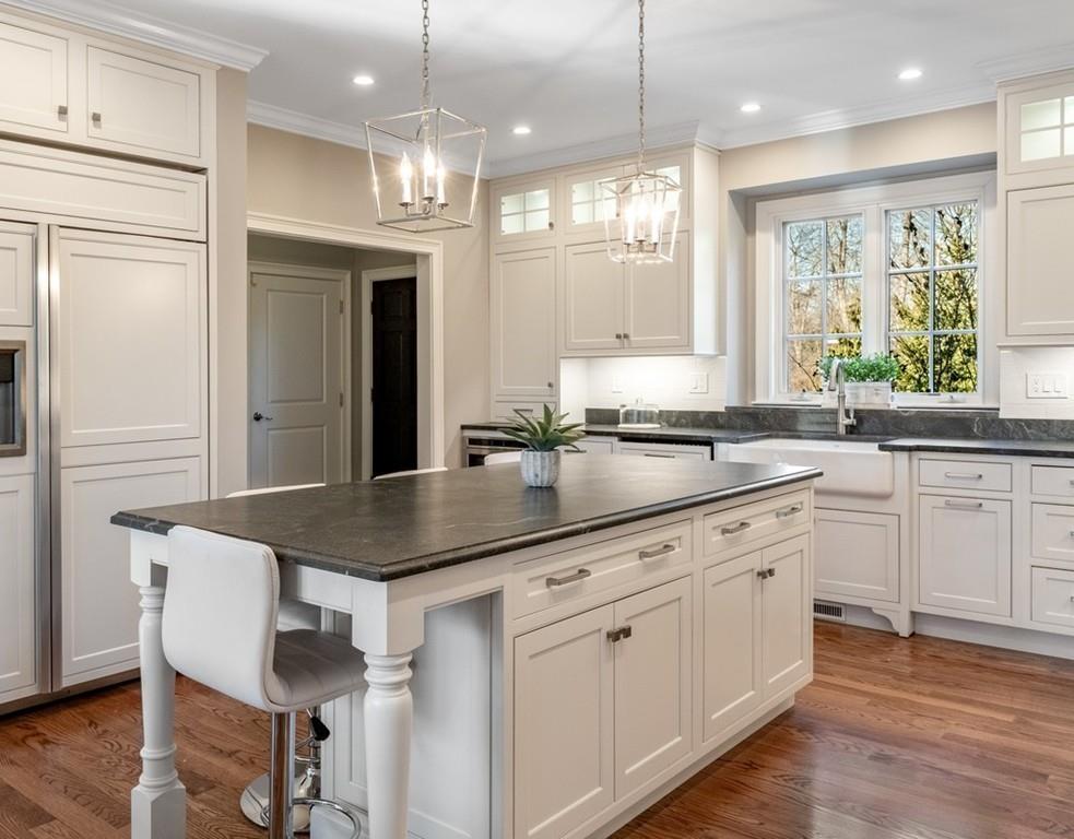 427 Lowell Road Concord, MA 01742 - Photo 7 of 35 a kitchen with kitchen island granite countertop a sink cabinets and wooden floor
