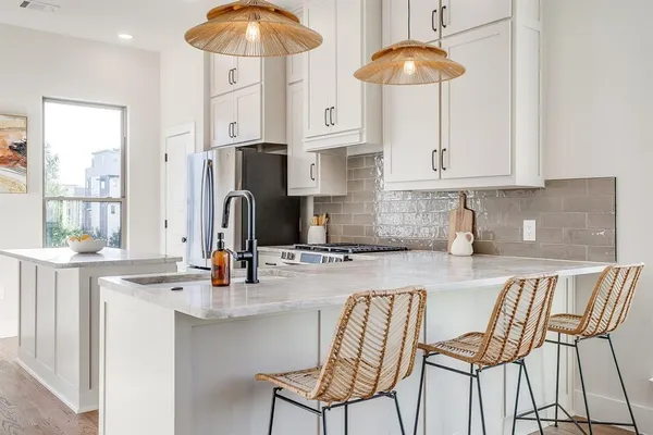 a kitchen with stainless steel appliances granite countertop a sink table and chairs