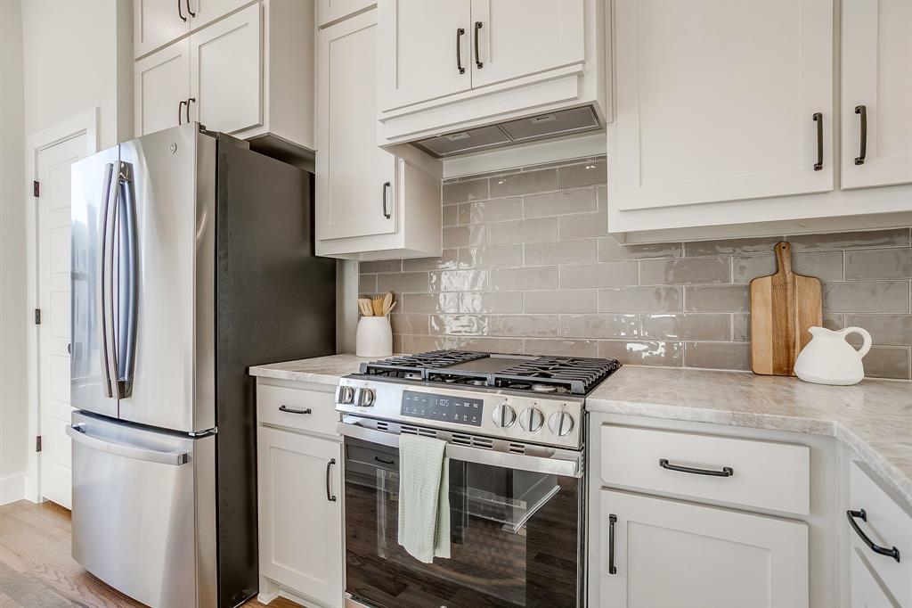 300 Foch Street, Unit 140 Fort Worth, TX 76107 - Photo 16 of 39 a kitchen with stainless steel appliances granite countertop white cabinets a refrigerator and a stove