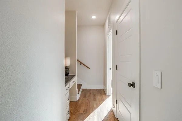 a view of a hallway with wooden floor and staircase