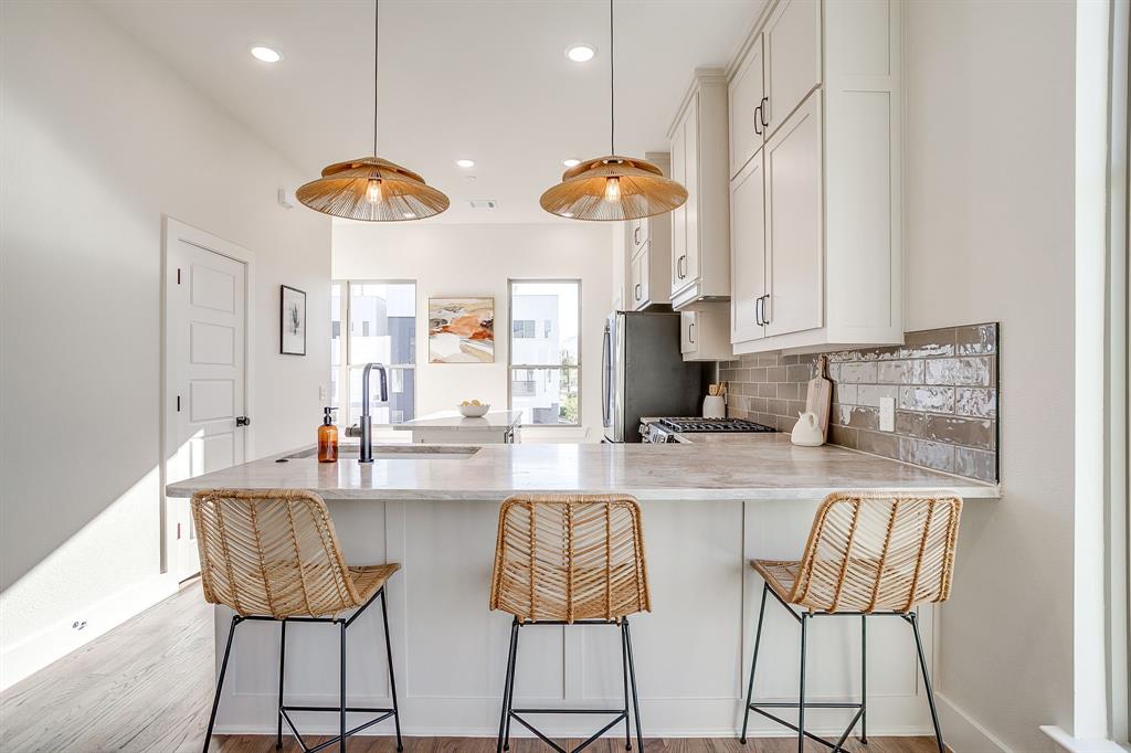 300 Foch Street, Unit 140 Fort Worth, TX 76107 - Photo 3 of 39 a kitchen with stainless steel appliances a dining table chairs and a refrigerator