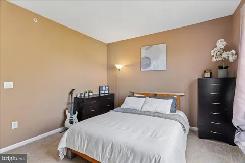 a bedroom with a bed and a lamp with the table