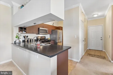 a kitchen with stainless steel appliances granite countertop a sink a stove and a refrigerator