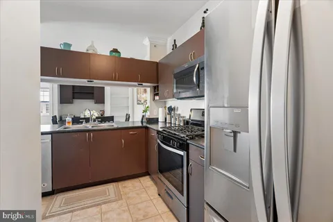 a kitchen with stainless steel appliances granite countertop a refrigerator and a sink