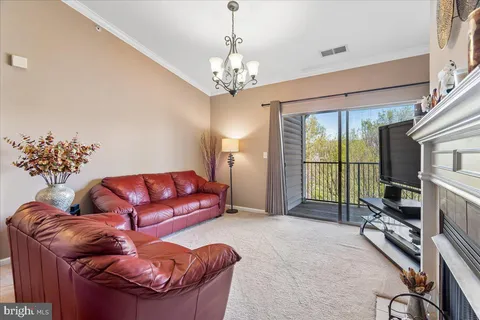 a living room with furniture a flat screen tv and a chandelier
