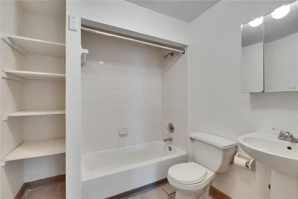 a white toilet sitting next to a bathroom sink and tub