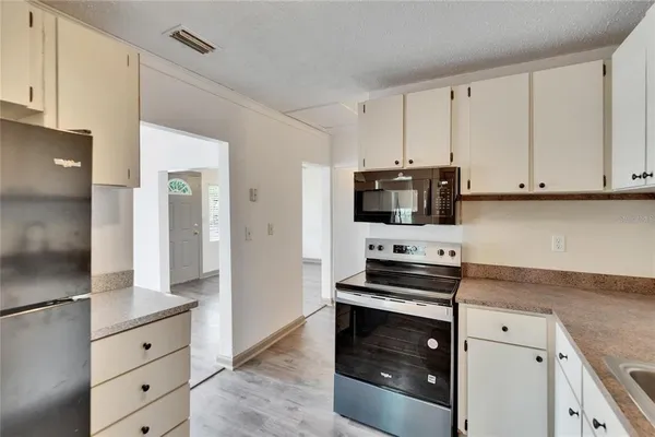 a kitchen with granite countertop white cabinets and stainless steel appliances