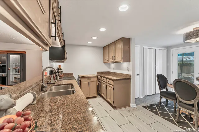 a kitchen with stainless steel appliances granite countertop a sink and a stove