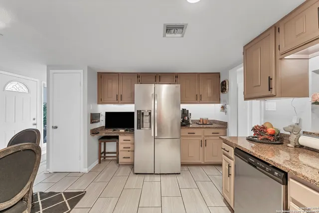 a kitchen with stainless steel appliances a stove a sink refrigerator and cabinets