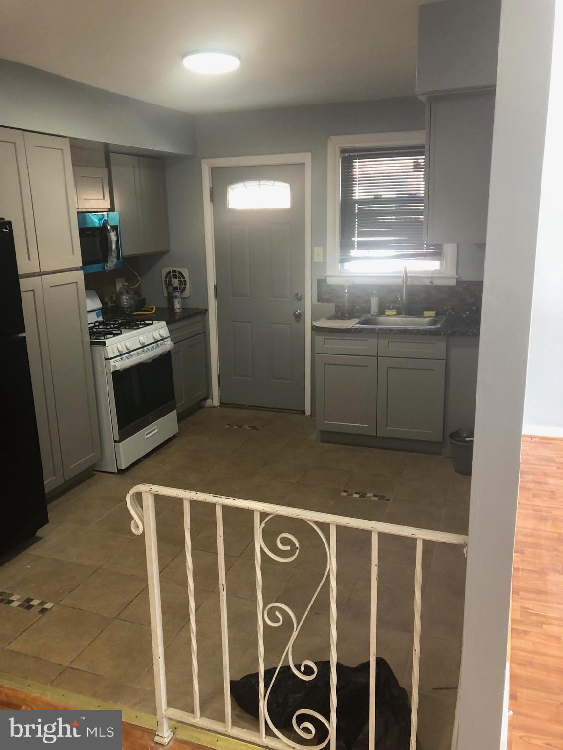 8550 Tolbut Street Philadelphia, PA 19152 - Photo 7 of 24 a kitchen with granite countertop a refrigerator a stove a sink and a window