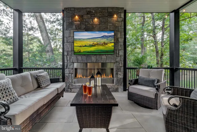 a living room with furniture a fireplace and a chandelier