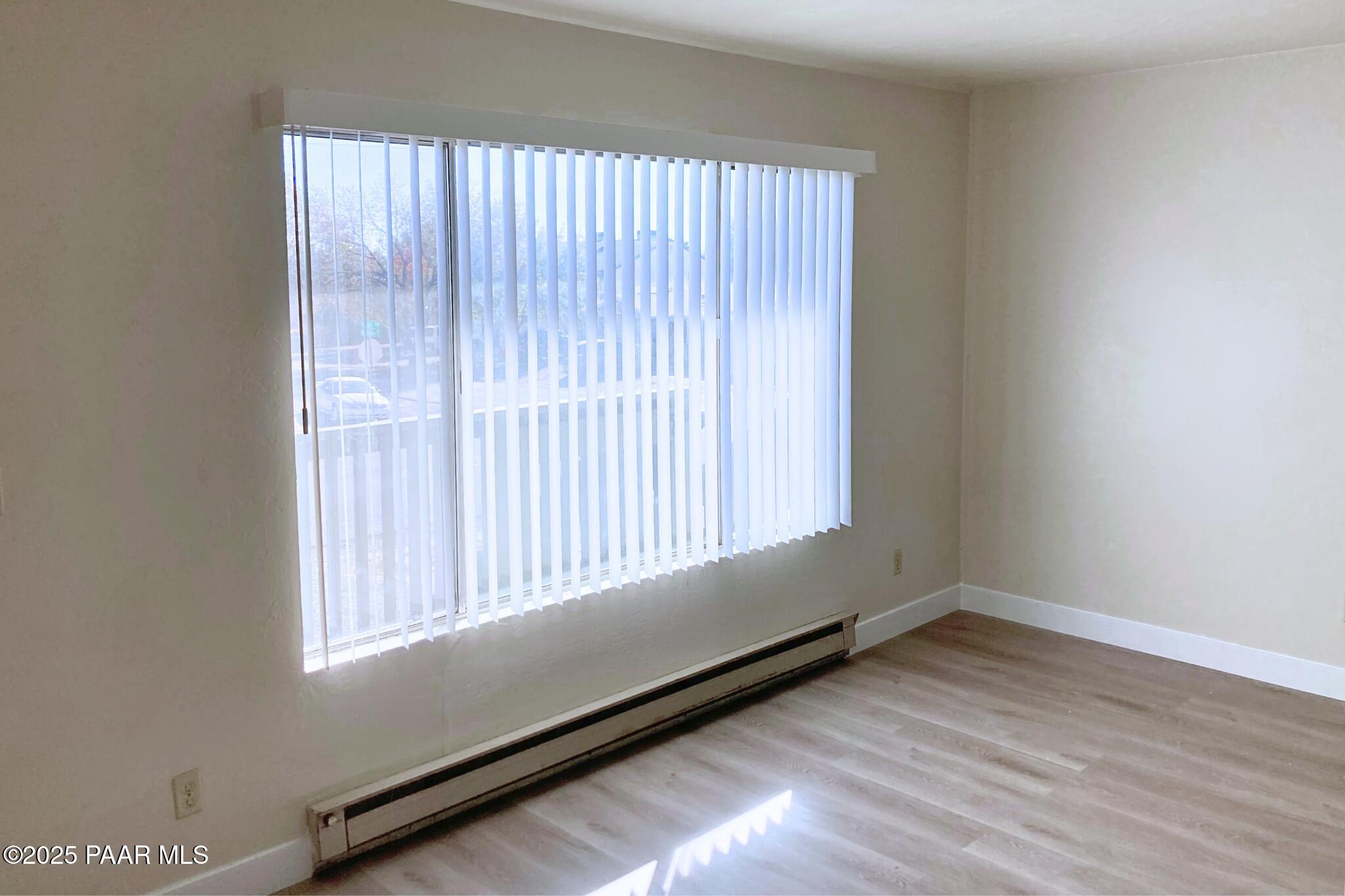 3184 North Tani Road, Unit 12 Prescott Valley, AZ 86314 - Photo 6 of 8 an empty room with wooden floor and windows