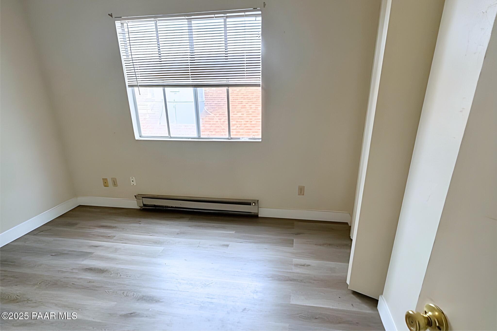 3184 North Tani Road, Unit 12 Prescott Valley, AZ 86314 - Photo 7 of 8 an empty room with wooden floor and windows