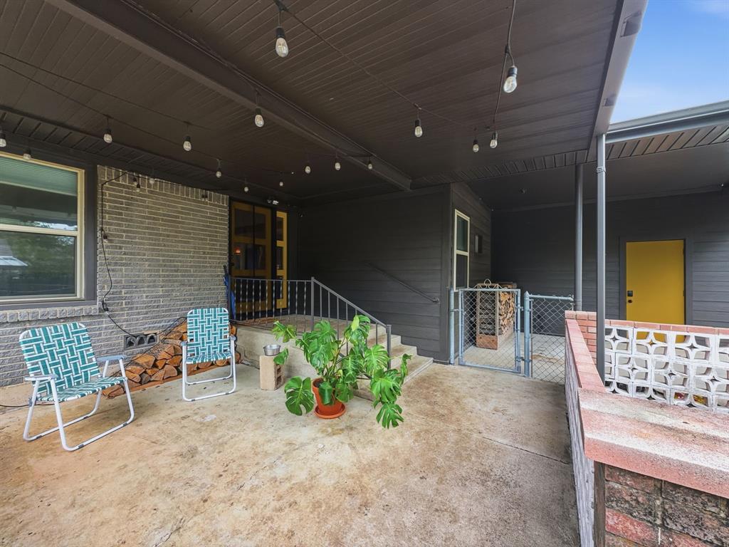 2137 Lenamon Street Waco, TX 76710 - Photo 22 of 29 Expansive concrete patio area featuring string lighting, a brick half-wall with decorative block accents, and a covered entry