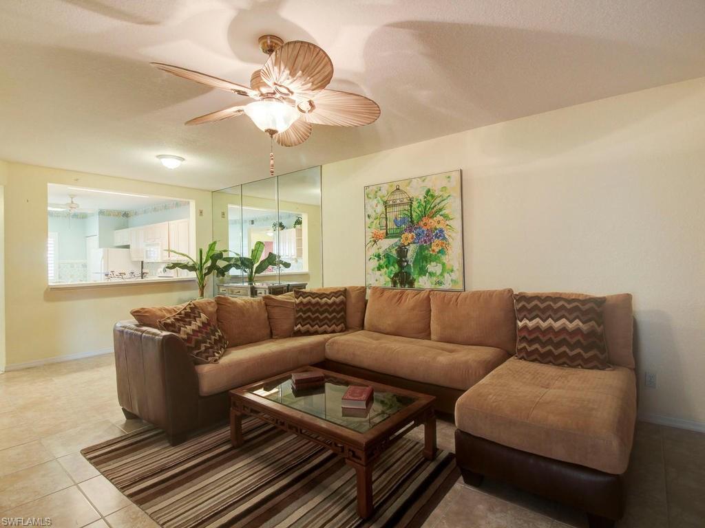 550 Gabriel Circle, Unit 3111 Naples, FL 34104 - Photo 13 of 25 a living room with furniture a chandelier and a window
