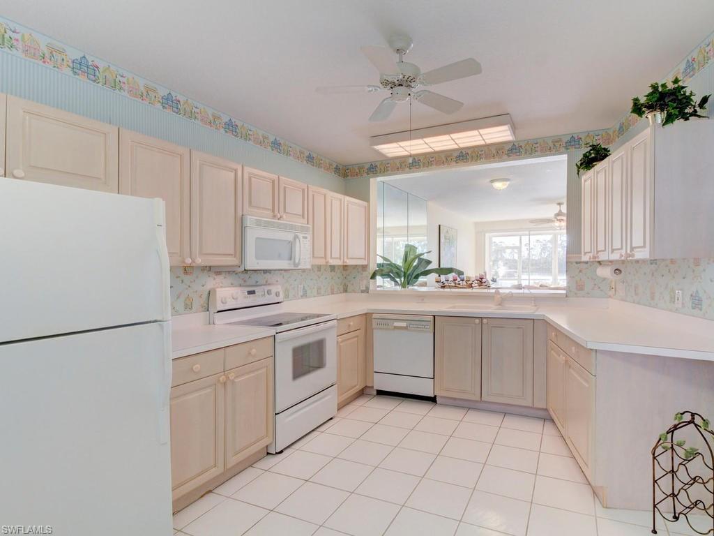 550 Gabriel Circle, Unit 3111 Naples, FL 34104 - Photo 15 of 25 a kitchen with white cabinets and white appliances