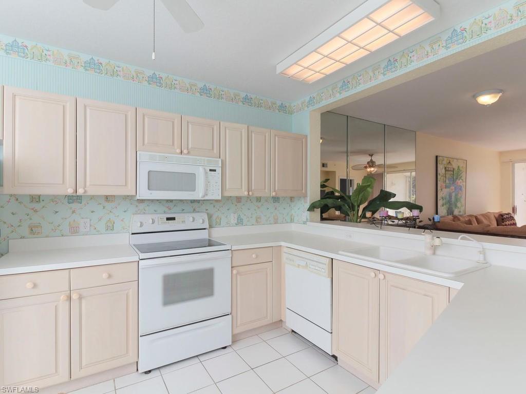 550 Gabriel Circle, Unit 3111 Naples, FL 34104 - Photo 16 of 25 a kitchen with white cabinets appliances and a sink