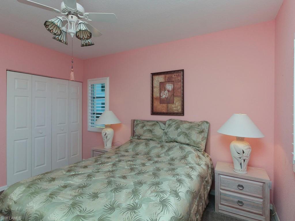 550 Gabriel Circle, Unit 3111 Naples, FL 34104 - Photo 18 of 25 a bedroom with a bed and a chandelier