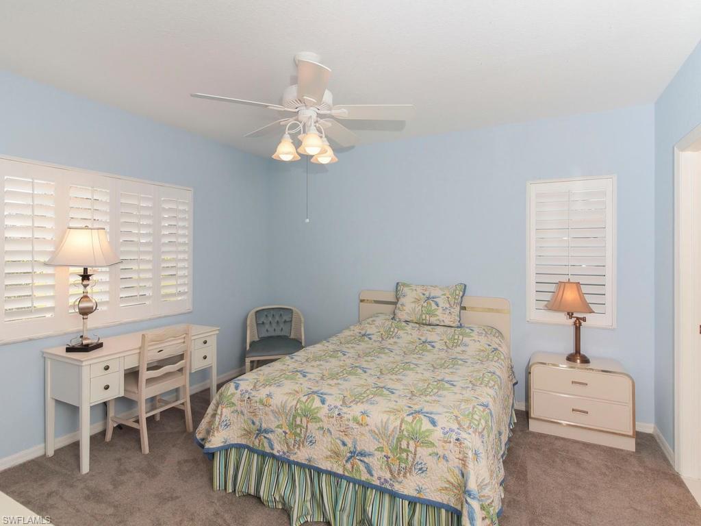 550 Gabriel Circle, Unit 3111 Naples, FL 34104 - Photo 20 of 25 a bedroom with a bed and a chandelier