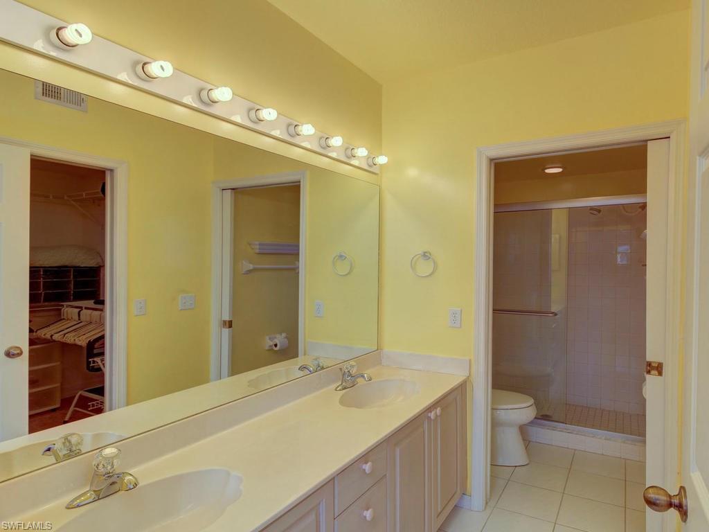 550 Gabriel Circle, Unit 3111 Naples, FL 34104 - Photo 25 of 25 a bathroom with a granite countertop sink a toilet and shower