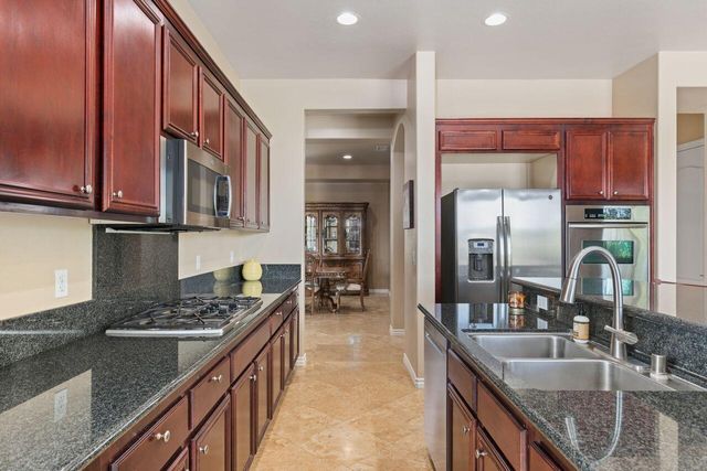 a kitchen with stainless steel appliances granite countertop a sink stove and cabinets