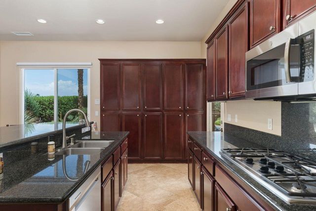 a kitchen with granite countertop a stove and a sink