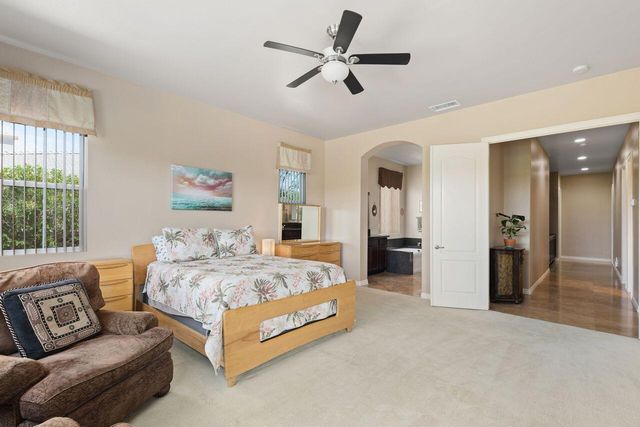 a spacious bedroom with a bed and ceiling fan