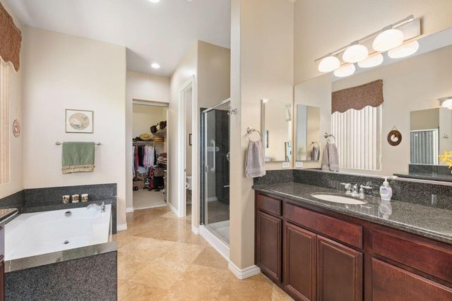 a spacious bathroom with a granite countertop sink and a mirror