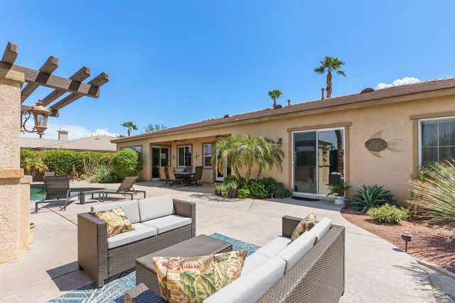 a view of a patio with couches table and chairs with potted plants