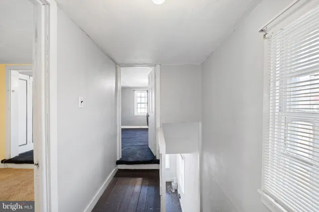 a view of a room with wooden floor and a bathroom