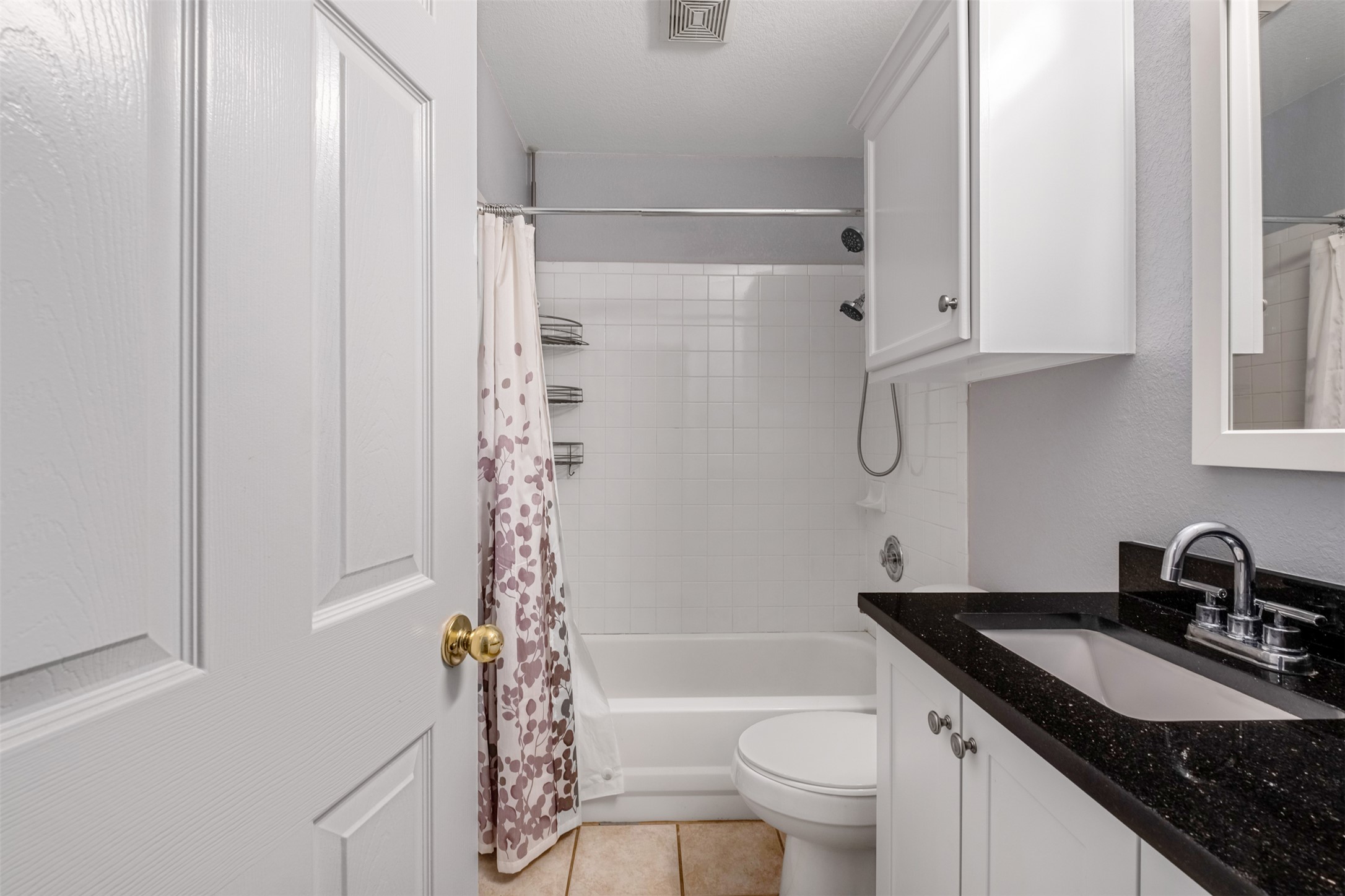 3413 Ruby Red Drive Austin, TX 78728 - Photo 16 of 19 A compact bathroom with bright tile and a dark granite vanity.