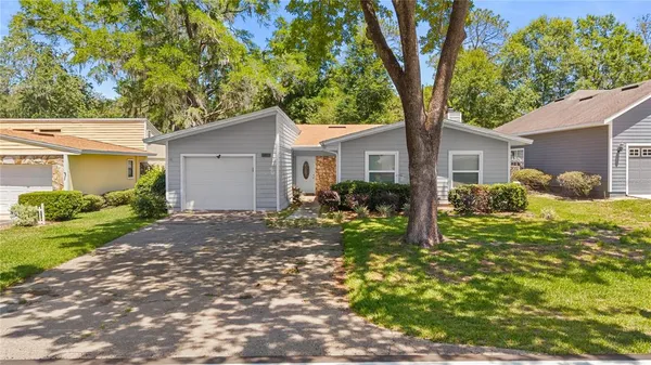 a front view of house with yard and trees around