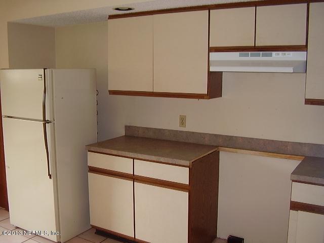 2465 Wattle Tree Road East Jacksonville, FL 32246 - Photo 7 of 11 a kitchen with a sink a refrigerator and cabinets