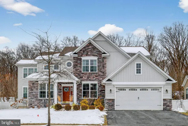a view of a white house with large windows and a yard with plants