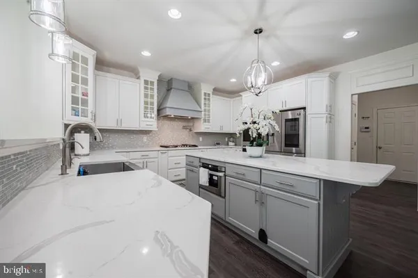a kitchen with kitchen island granite countertop a sink a counter space appliances and cabinets