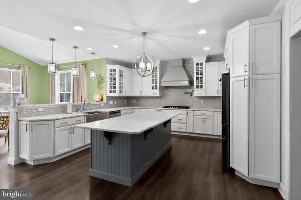 a kitchen with kitchen island granite countertop a sink appliances and cabinets